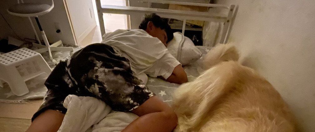 息子と愛犬の熾烈な寝床争い！どう見ても「壁際を陣取った方が勝ち」な状況に笑みがこぼれる